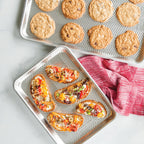 Chevron-pattern metal baking trays, one with cookies and one with mini pizzas