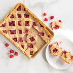 Nonstick quarter sheet pan with cut berry lattice pie and scattered crumbs