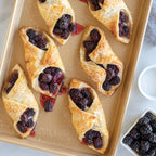 Tan jelly roll sheet pan with berry-filled pastry bites and pastry tops