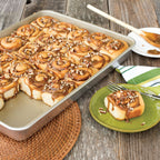 Nonstick high-sided sheet cake pan filled with cinnamon rolls, on a plate