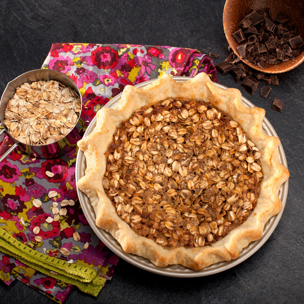 Beige pie pan holding baked pie with textured golden crust