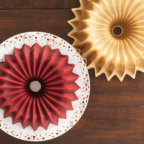 Gold fluted bundt pan with scalloped ridges, shown with bundt cake