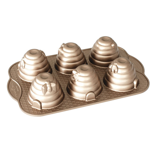 Beehive cakelet pan with cone-shaped baked cakes in molded wells
