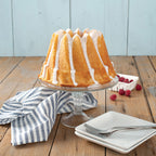 Bundt cake pan holding a finished cake with white icing drips