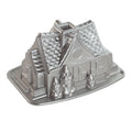 Silver metal gingerbread house bundt pan mold with detailed house design and base tray