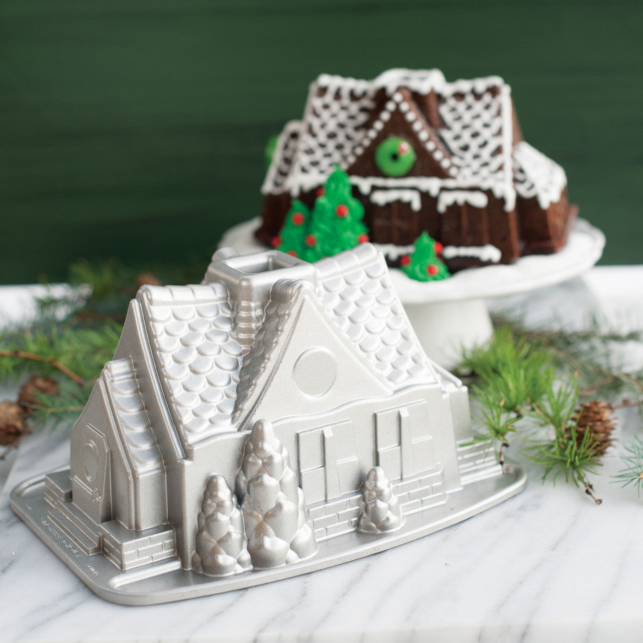 Silver metal gingerbread house bundt pan mold with house silhouette and base