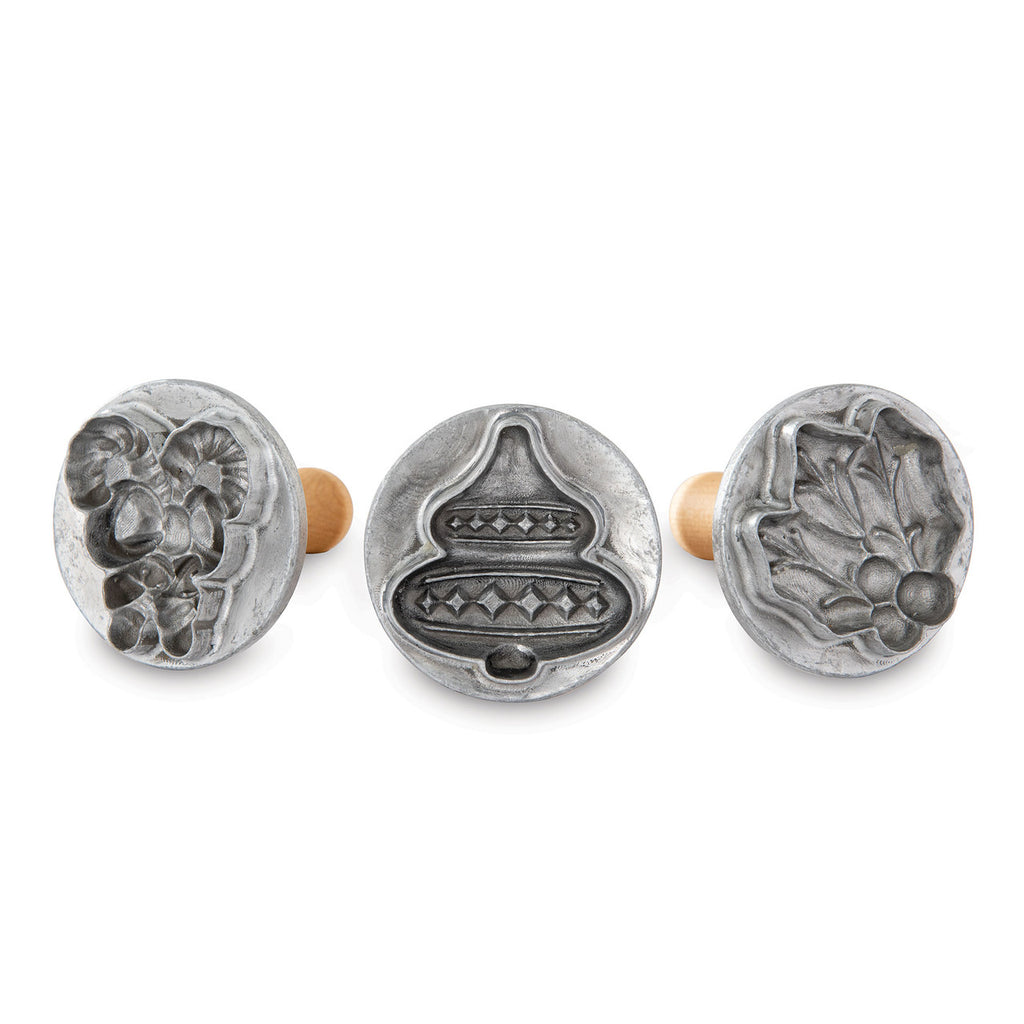 Three silver holiday cookie stamp molds with raised 3D cut-out patterns
