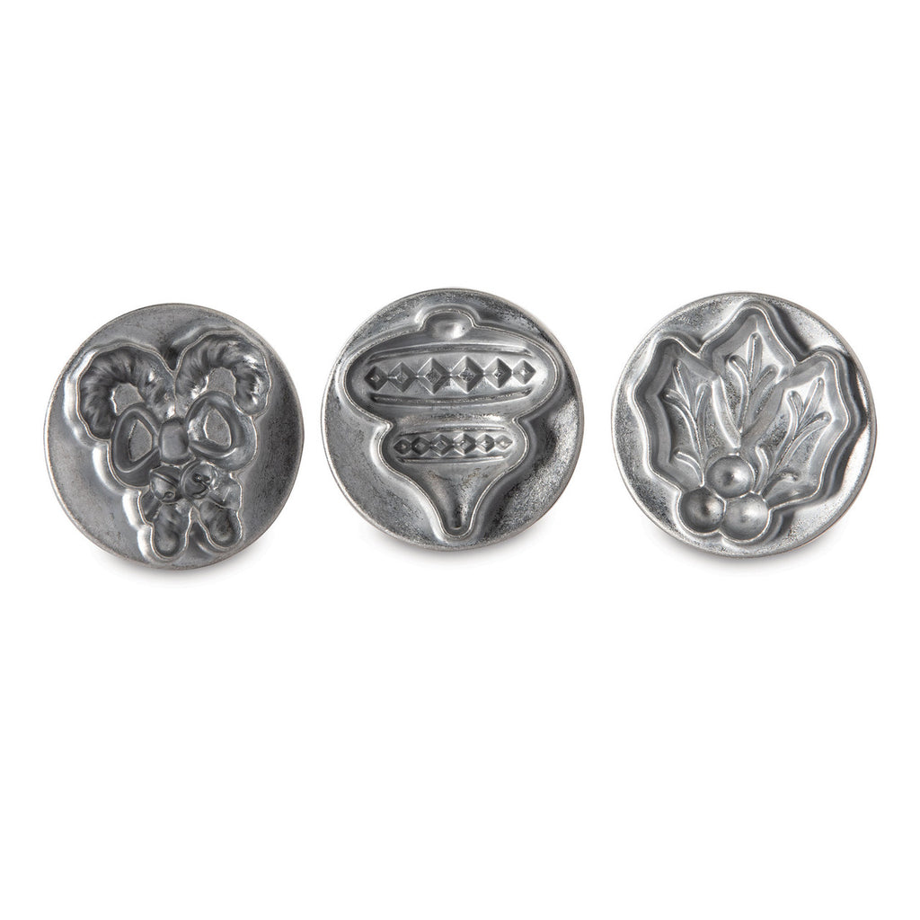 Three silver holiday cookie stamp molds featuring raised 3D patterns