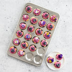 Petite cupcake tray filled with pink swirled frosting cupcakes and two on plate